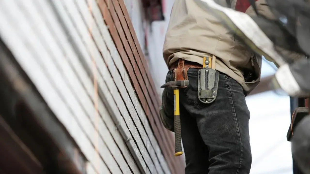 Entrepreneur en rénovation portant sa ceinture à outils sur un chantier